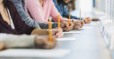 Cropped view of group of teenagers taking a test